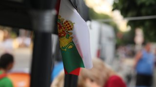 Не, на българския флаг няма герб, няма и други символи или шарении. И да, поставянето им е обида за знамето