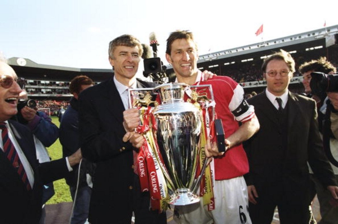 1997/98: Първата титла на Венгер
Този сезон треньорът на Арсенал се очаква да подобри рекорда на Фъргюсън за най-много мачове начело във Висшата лига. Всичко започна много отдавна – и по точно, когато спечели първата си титла на Англия. На снимката Венгер празнува заедно с капитана на Арсенал Тони Адамс трофея на 3 май, 1998-а. По-късно френската революция в тима доведе до дубъл.