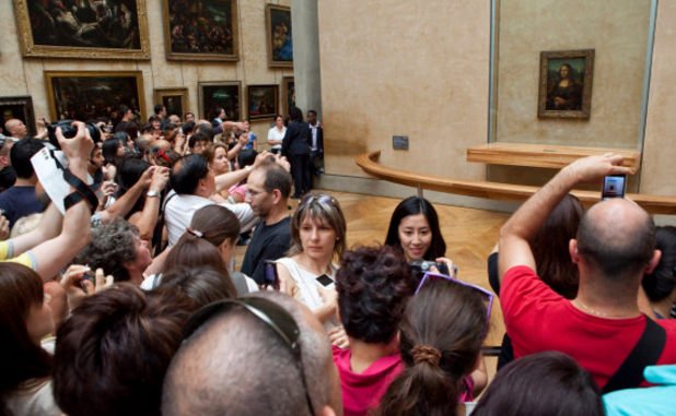 Да стигнеш до „Мона Лиза“ е трудно. Ограничителна лента разделя посетителите от картината. Заклещени зад орди от снимащи с камери туристи, вие ще сте дори по-далеч от линията.
