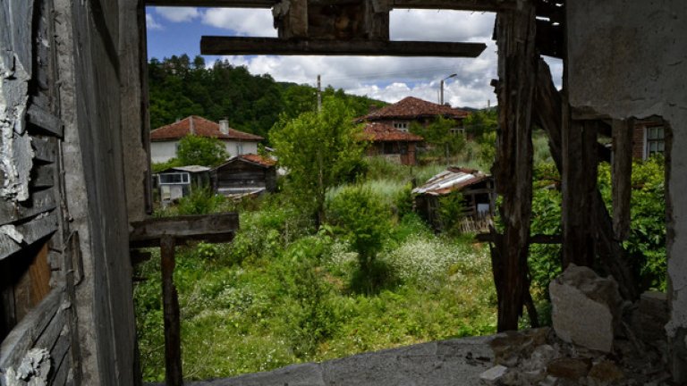 Останките от рухналата стена тъжно гледат към обитаемите къщи в съседство.