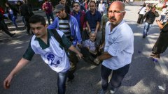 Доброволци изнасят ранен възрастен мъж от мястото на атентата в Анкара