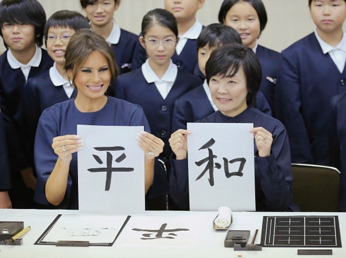 Мелания държи лист с калиграфски изписан йероглиф, който означава "мир".