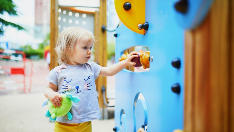 Adorable toddler girl having fun on playground