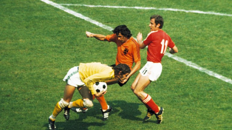 Партийци нареждат как да пазим Кройф

Холандия – България 4:1, 23 юни 1974 г., Дортмунд

Единственият мач между двата отбора на големи футболни финали. На световното в Германия през 1974 г. България и Холандия се падат в една група. В първите си две срещи нашите постигат равенства срещу Швеция (0:0) и Уругвай (1:1), което управляващите в София възприемат като провал. Издадено е нареждане, че трябва да бием Холандия на всяка цена. Сутринта преди мача в българския лагер пристига цяла делегация партийни величия от ЦК на БКП, предвождана от известния левскар от Политбюро Борис Велчев. Отговорните другари привикват на разбор треньора Христо Младенов. Месят се в определянето на състава, дават акъл кой да играе и кой не. Нещо повече – разпореждат, че холандският капитан Йохан Кройф трябва да бъде охраняван зоново, без да му се поставя персонален пазач. А футболистите са заплашени, че ако се изложат, у нас ще ги линчуват по партийни и профсъюзни събрания.
Унизени и със смачкано самочувствие, българските национали губят с 1:4 мача в Дортмунд. Два гола на Джони Реп от дузпи, и по един на Йохан Неескенс и Тео де Йонг носят победата за Холандия. За да не сме съвсем капо, към края Руди Крол си вкарва автогол. Сред голмайсторите обаче липсва Йохан Кройф, което показва, че партийните другари все пак са намерили решение за обезвреждането му.
