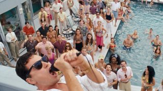 Джордан Белфорт (Леонардо ДиКаприо) стои на тераса над огромен басейн, пълен със служители на неговата брокерска фирма „Стратън Оукмънт", и ги надъхва с една от многото си мотивационни речи, които имат въздействието на поетични оди за алчността и себичността.
