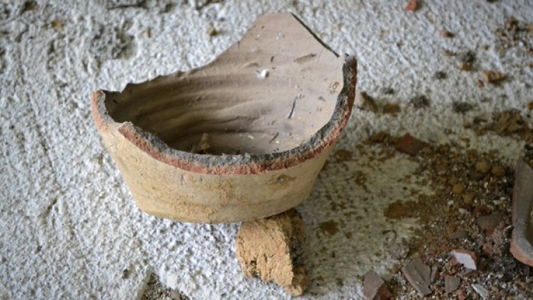 Останките от някогашни глинени съдове напомнят за миналото, когато сградата е била обитаема.