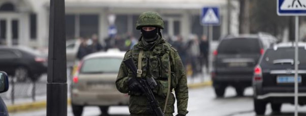 An armed man patrols at the Simferopol airport in the Crimea region