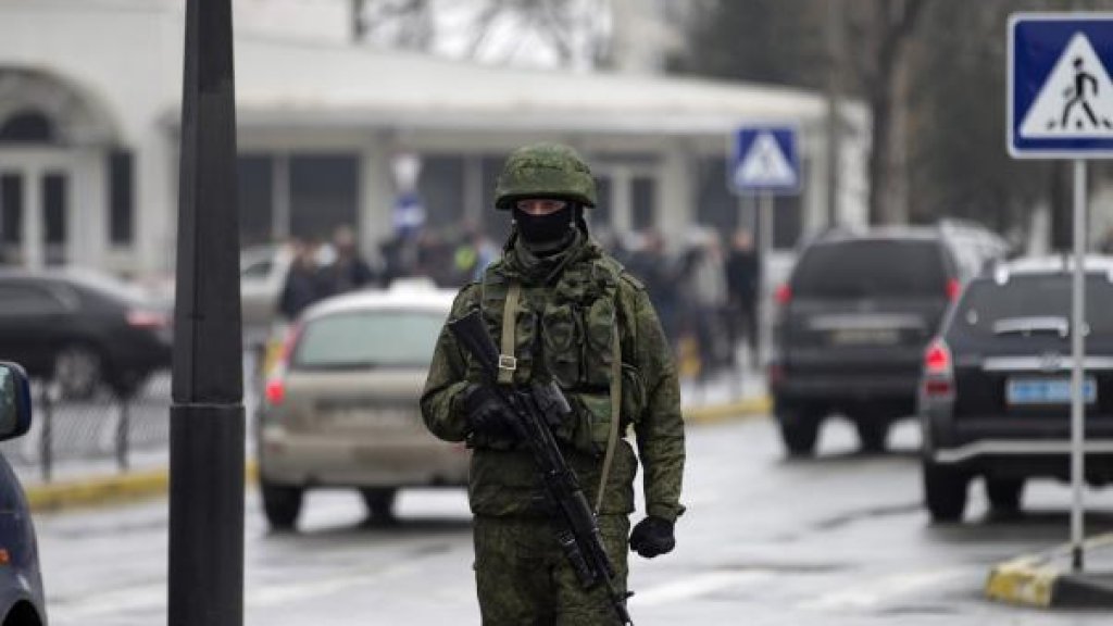 An armed man patrols at the Simferopol airport in the Crimea region