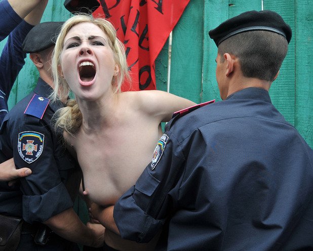 5 юли 2011 година. Украински полицаи арестуват активистка на феминисткото движение ФЕМЕН пред парламента в Киев. Тя и нейните съмишленици протестират срещу повишаването на пенсионната възраст за жените в Украйна.Снимка: AFP/Genya Savilov/Геня Савилов