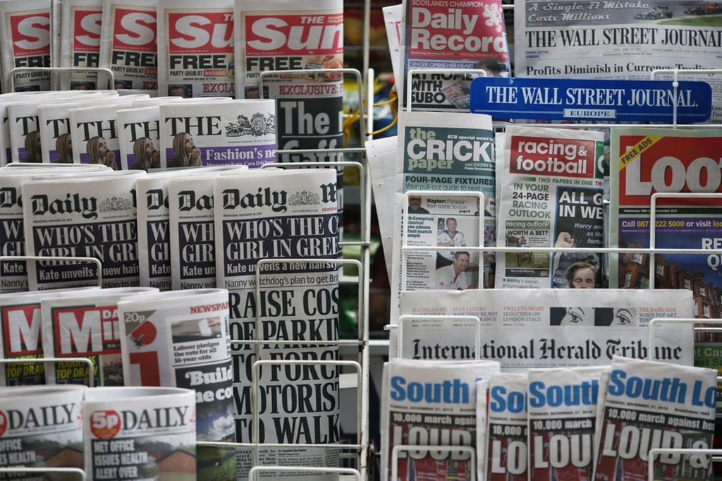 Newspapers are displayed on a stand outside a newsagent -1464267