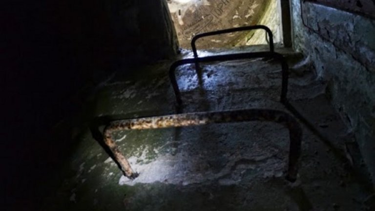 Ръждива стълба изплува от мрака и отвежда към вътрешността на едно железобетонно картечно гнездо.