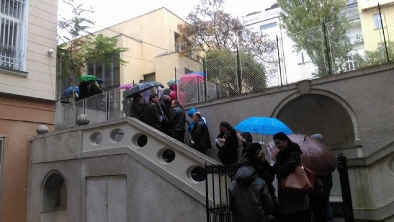 В Прага вали дъжд, а хората чакат по стълбите.