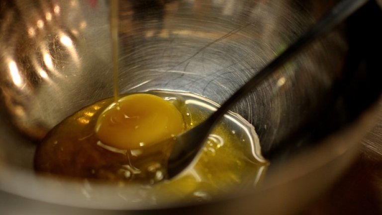 Разбийте с вилица яйцата, докато наливате затопления мед