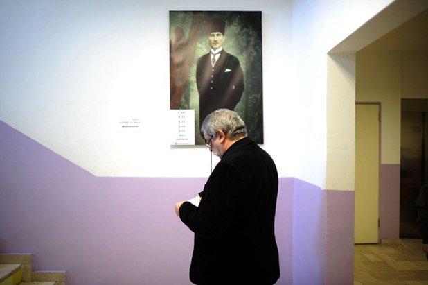 Гласоподавател пред портрета на Мустафа Кемал Ататюрк - основател на Република Турция, отговорен за разделянето на светската от религиозната власт в страната 