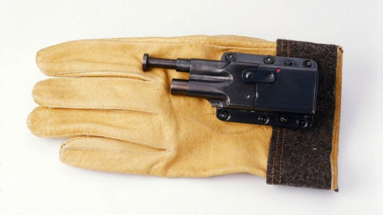 Ръкавицата-пистолет е разработена от американските морски пехотинци по време на Втората световна война. Дори няма нужда да я сваляте, за да постигнете смъртоносен ефект. Достатъчно е да се здрависате с жертвата си - допирът в ръката му освобождава спусъка и куршумът пронизва тялото му мигновено. 