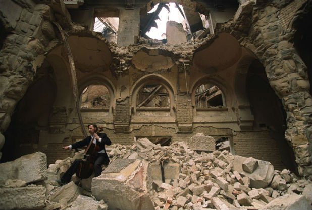 "Челистът на Сараево" Ведран Смайлович свири в разрушената Национална библиотека по време на войната в Босна и Херцеговина. Снимката е на фотографа Михаил Евстатиев от 1992 г.