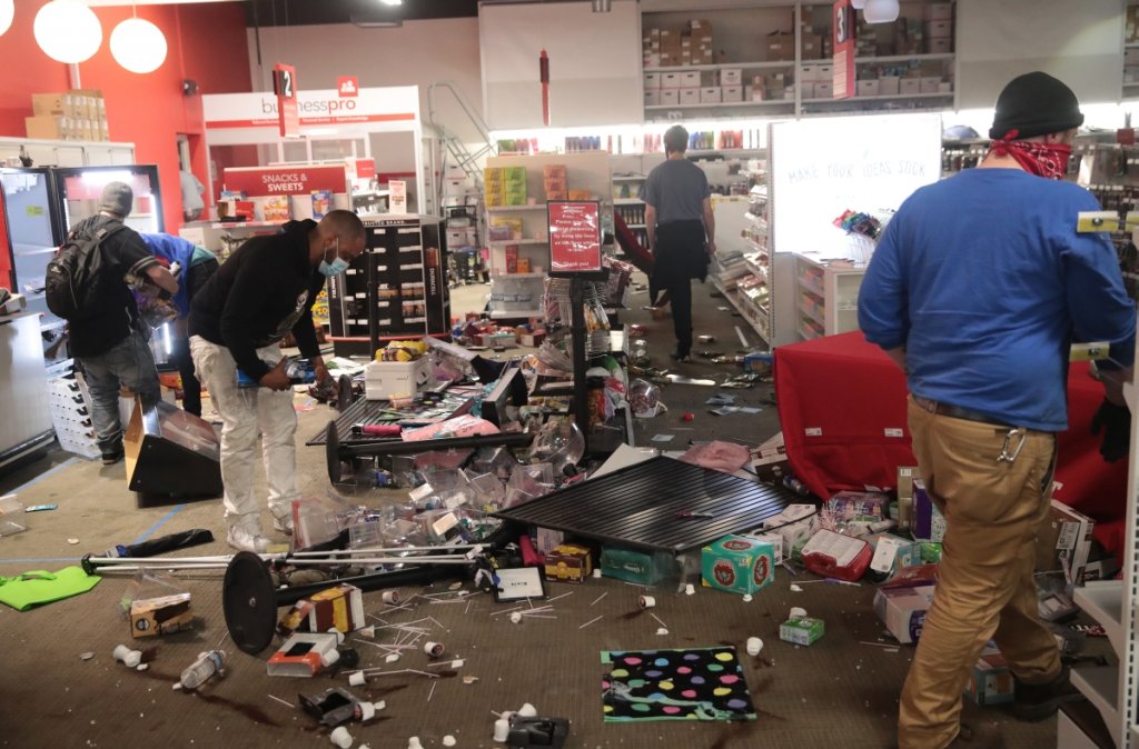 Хора обикалят из магазин, разбит по време на протестите в Минеаполис.