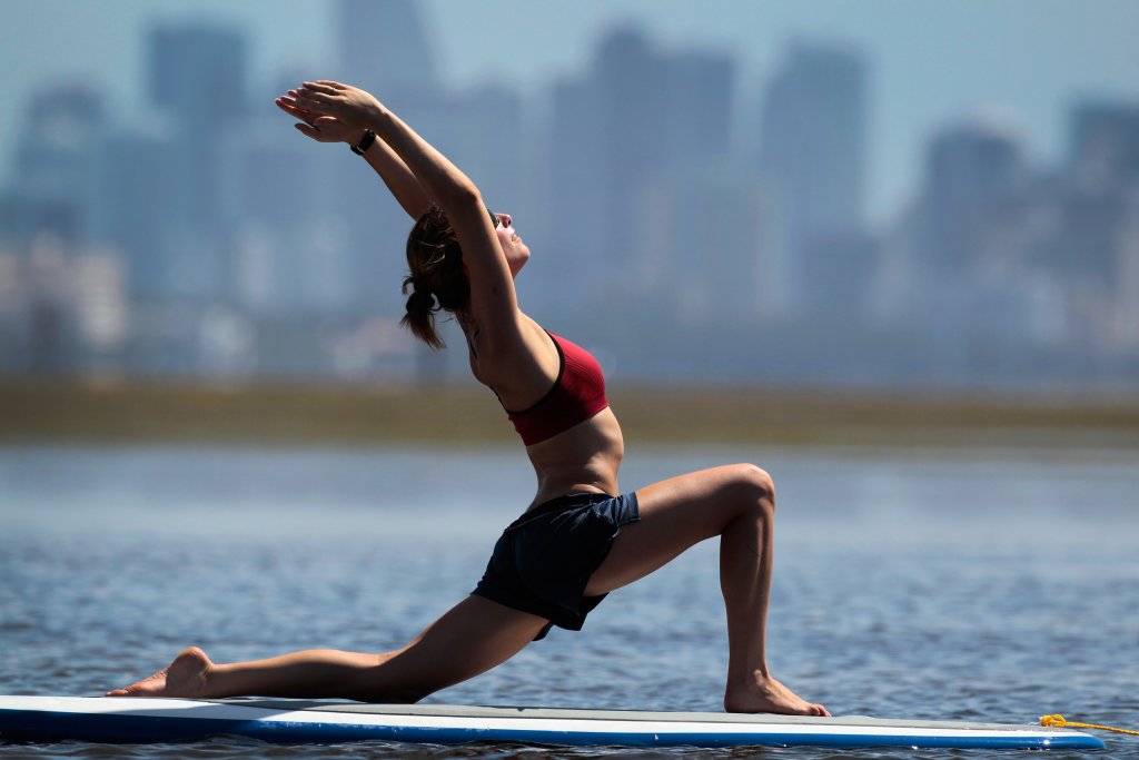 Practioners Enjoy Serenity Of Paddleboard Yoga