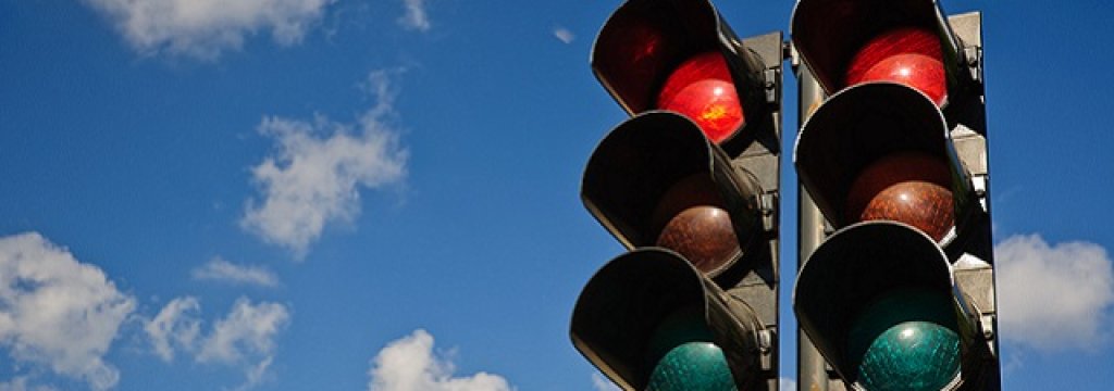 A couple of red traffic lights against a blue sky