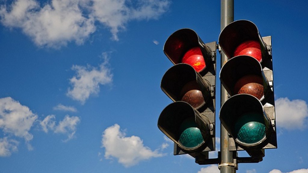 A couple of red traffic lights against a blue sky