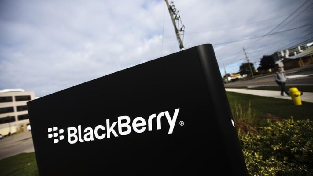 A man walks by a Blackberry sign at the Blackberry campus in Waterloo