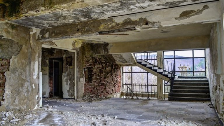 Разрухата се е пропила в стените на сградата. Прозорците са изпочупени, мазилката пада, а влагата и мухълът неудържимо завземат цялата й територия.