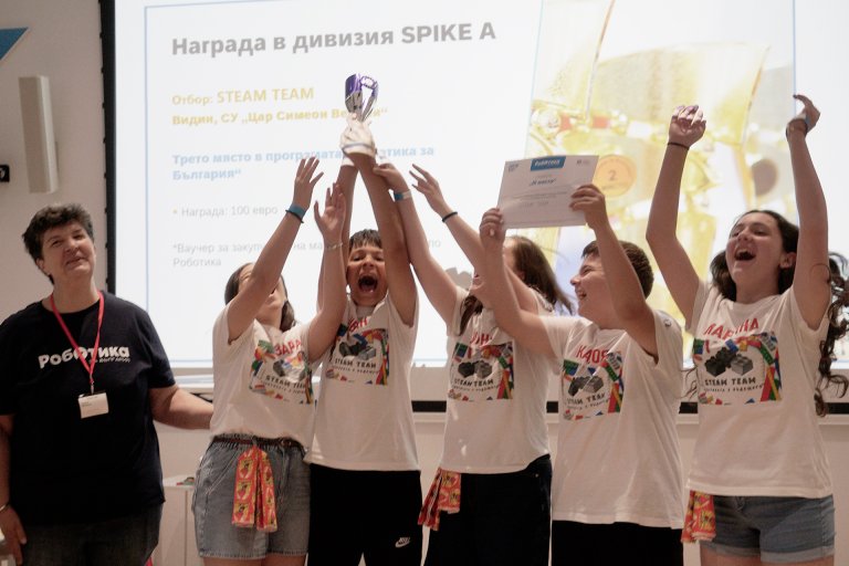Изпълнителният директор на Фондация "Работилница за граждански инициативи" Илияна Николова награждава един от отборите на "Роботика за България" 2026