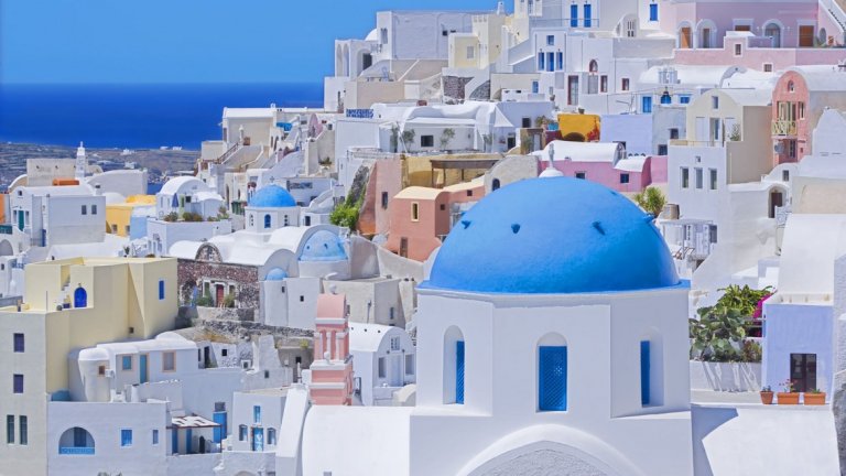 Остров Санторини
Пейзажът на остров Санторини е едно от нещата, за които се сещаме като чуем Гърция – измазани в бяло къщи със сини покриви, които контрастират на тъмните скали на острова и водите на Егейско море.
Една от най-големите забележителности на Санторини е така наречената калдера – кратер, запълнен с вода, който се образува при изригване на вулкана на острова през 1400 година пр.н.ера. Според някои учени това е най-голямото вулканично изригване, което някога се е случвало на земята.
Има предположения, че именно на този остров е живяла мистичната цивилизация на Атлантида, изчезнала след изригването. На територията на Санторини са открити находки, които доказват ранното наличие на развита цивилизация. Останките от минойската цивилизация могат да бъдат видени в село Акротири в най-югозападния край на острова. В селото има руини от стара крепост, а разкопките са много добре запазени.
На края на острова е и селцето Ия, от което се разкрива една от най-красивите гледки към залеза. От пристанището на селото до върха има 258 стъпала, но пейзажът, който се разкрива, си заслужава изкачването.
