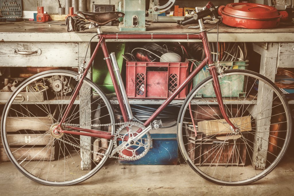 Vintage racing bycicle in front of an old work bench with tools