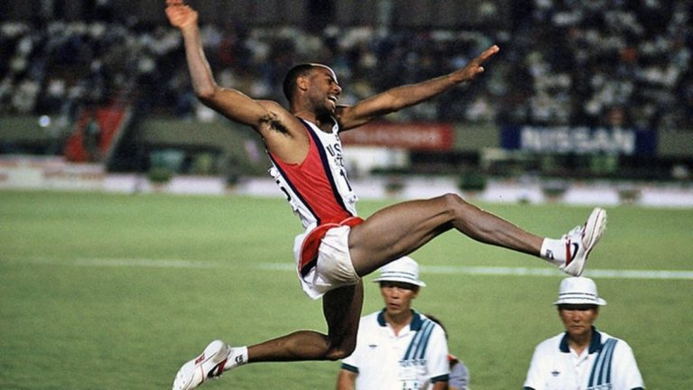 Майк Пауъл, скок на дължина

Вечерта на 30 август 1991 г. се оказва историческа за леката атлетика. На световното първенство в Токио американецът Майк Пауъл се приземява в сектора за дълъг скок на 8.95 м. Прави го при петия си опит. Световният рекорд на Боб Биймън от 8.90 м, регистриран цели 23 години по-рано, заминава в нафталина. 
Постижението на Майк Пауъл е наистина забележително, тъй като рекордът е поставен в люта финална надпревара срещу легендарния Карл Люис. Специалистите определят надскачането между двамата в Токио като най-голямата атракция в тази дисциплина за всичко времена. Година по-късно Пауъл скача 8.99 сек, но заради попътния вятър от 2 м/сек постижението не е признато за рекорд. 

