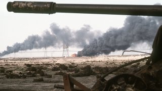 1280px-Disabled_Iraqi_T-54A,_T-55,_Type_59_or_Type_69_tank_and_burning_Kuwaiti_oil_field
