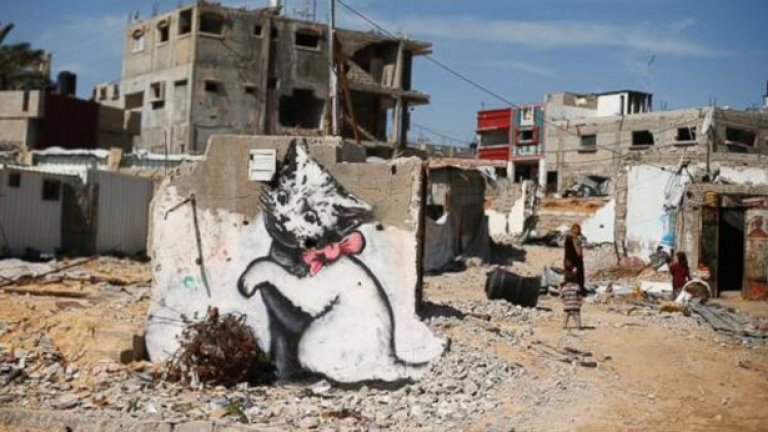 Един от графитите показва бяла котка с панделка, която символизира безразличието на света към конфликта между израелци и палестинци