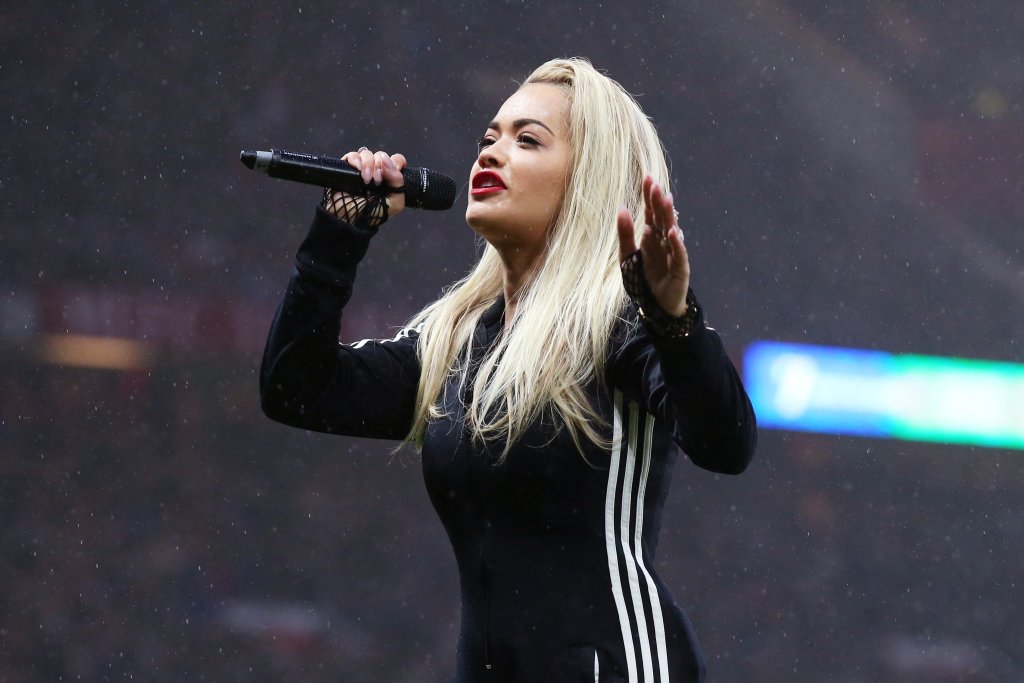 Облечена в в цял анцуг с трите ленди на adidas, Ора пя по време на благотворителния мач на UNICEF, игран на „Олд Трафорд“ преди около месец