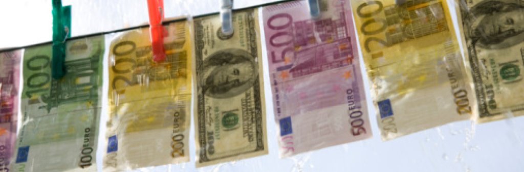 Papper currency hanging on washing line in the rain