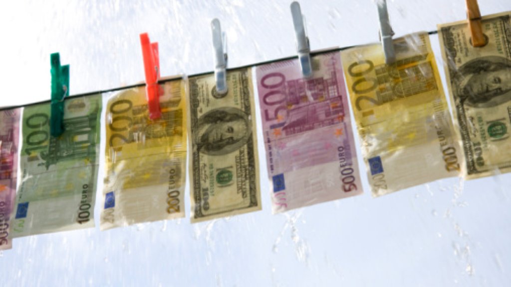 Papper currency hanging on washing line in the rain