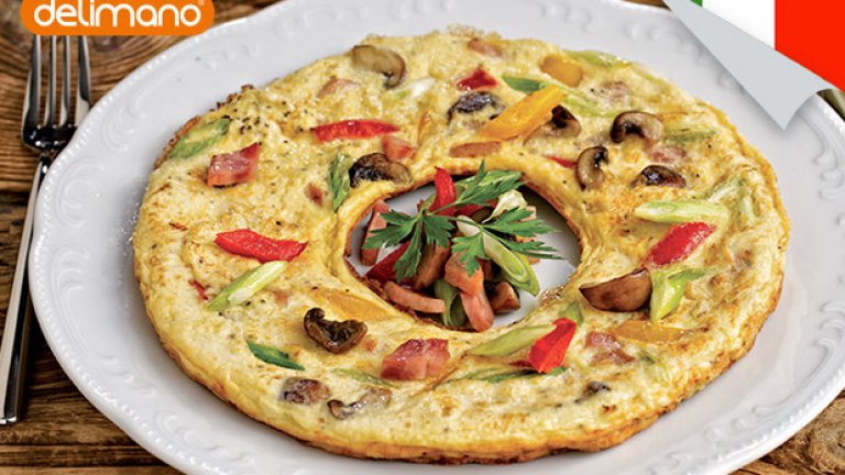 1. Италианска Фритата с шунка и зеленчуци
• Нарязани на ситно: 3 стръка пресен лук, 2 чушки, зелена и червена 100 г шунка, 50 г меко козе сирене, 8-10 гъби • 10 яйца • магданоз • зехтин • пипер • сол
Затоплете 1-2 супени лъжици зехтин в универсален тиган Деличия и запържете лука на бавен огън. Добавете шунката и я запържете леко. Прибавете гъбите и чушките, поставете капак и гответе, докато продуктите омекнат. Разбийте яйцата със сол и пипер. Изсипете ги върху сместа от шунка и зеленчуци. Намалете температурата и поръсете отгоре с нарязаното сирене. Поставете капак и гответе, докато фритатата се изпържи. Сервирайте с украса от пресни зеленчуци и магданоз.