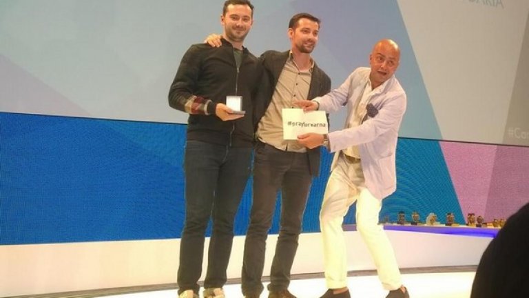 Влади Герасимов (в средата) и Желез Атанасов тъкмо получават наградата си в Кан от председателя на журито Амир Касай, който придържа и табелата #prayforvarna