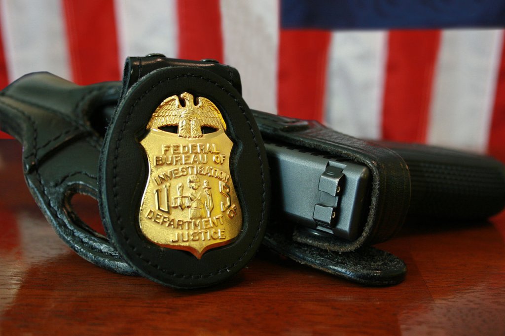 1280px-FBI_Badge_&_gun
