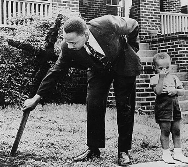 Мартин Лутър Кинг отстранява изгорял кръст от двора си, заедно със своя син, 1960 г.

