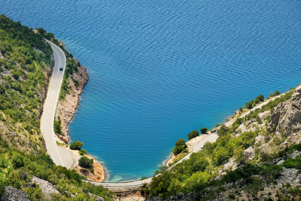 Адриатическата магистрала, Хърватска

Ядранската магистрала, както се нарича в Хърватска, се движи по крайбрежието и край кристалните води на Адриатическо море от Риека до Дубровник. Има и много спускания, серпентини и завои, а в далечината се виждат и островите. Пътят минава край градчета с характерните къщи с червени покриви и средновековни руини, а основната атракция е при минаването при планината Велебит, с което се открива гледка към остров Паг.
