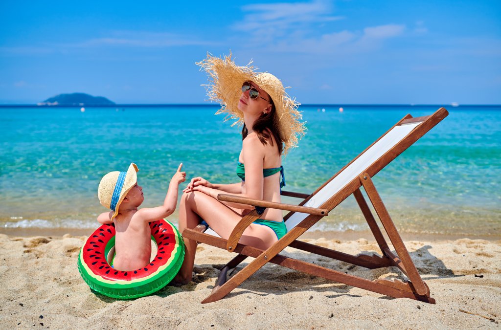 Toddler boy on beach with mother