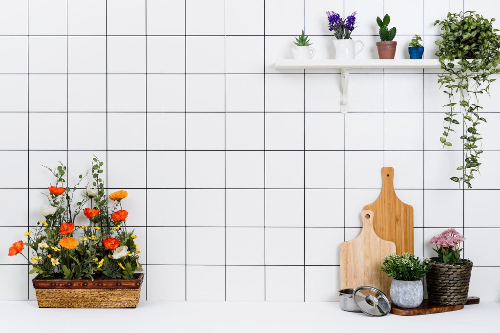 Ами едни истински цветя?Не е много трудно да си представим тази снимка без цветята на нея - бели плочки и един рафт. Точно така най-добре личи силата дори на скромното озеленяване, при това не задължително в хола. Един рафт, на който да сложиш пълзящо растение или колектив от малки кактуси, наистина може доста да разнообрази обстановката. Да не говорим пък за някое цитрусово джудже (като определени видове лимон и портокал), на които обаче ще трябва да осигурите и доста светлина, за да ви се отблагодарят с плодове.