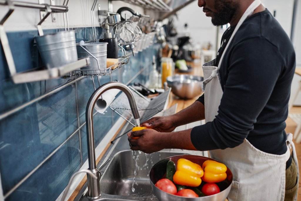 Man Washing Vegetables in Sink