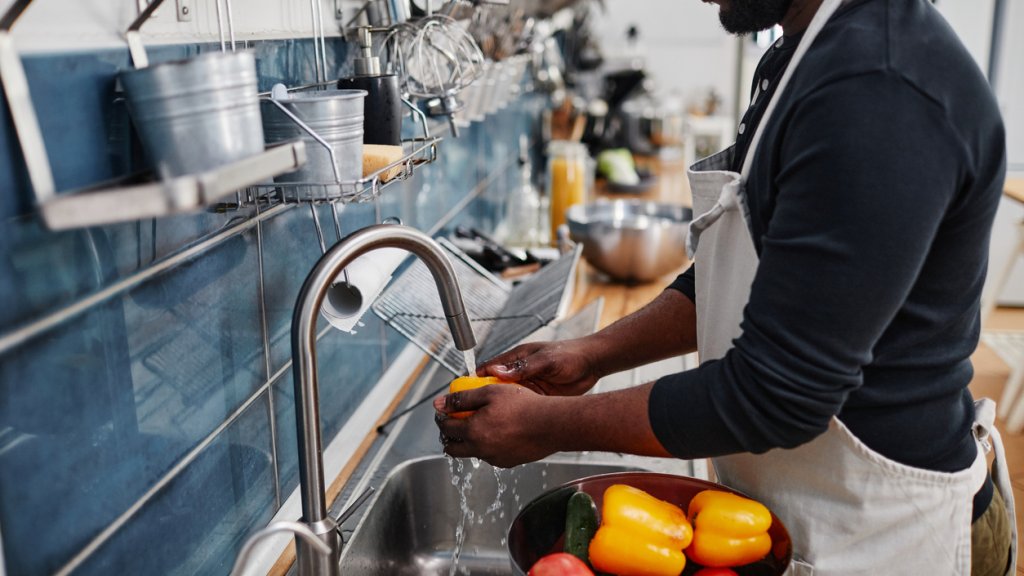 Man Washing Vegetables in Sink