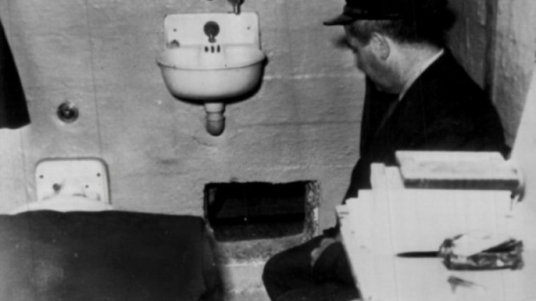 Пазач разглежда дупката през която Кларънс и Джон Енглин и Франк Морис са избягали. Дупката е изровена с лъжици