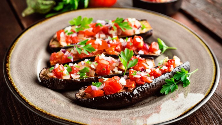 Пълнени патладжани с домати и фетаЗасищащите патладжани нямат нужда от много продукти, за да са вкусни. По-малки патладжани според броя на гладните се разполовяват и издълбават. Поръсват се със сол и малко зехтин и се оставят настрана. През това време в дълбок тиган се запържват глава лук, няколко скилидки скълцан чесън, вътрешността на патладжана и 500 грама домати на кубчета.
Подправя се със сол, пипер, риган и босилек, а когато доматите омекнат и сместа се сгъсти се прибавят и 200-300 грама сирене фета на кубчета. Патладжаните се пълнят и се пекат на 170 градуса до покафеняване. Можем да използваме и чери домати, както и друг вид сирене според наличността.