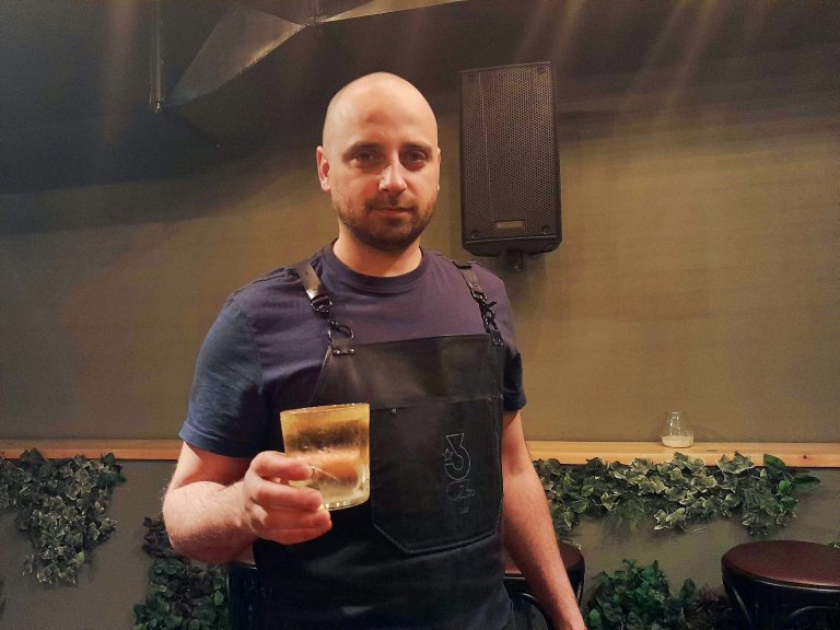 Цветан Цветанов, един от основателите на бар "3 унции", който позира със създатения от него коктейл.