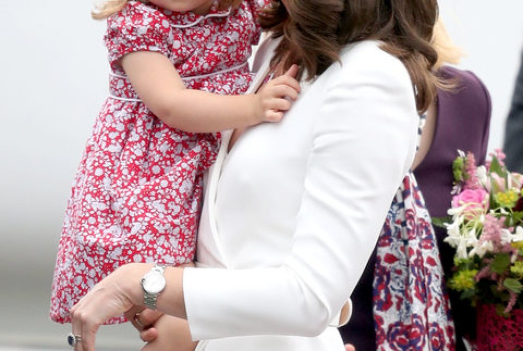 Шарлот е в прегръдките на майка си след кацане в Полша за кралска визита.