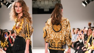 Versace
В цялата история на съществуването си Versace винаги е бил “лъскав” бранд. Логото му - митологичното същество Медуза, е лесно разпознаваемо. Самата къща често поставя името си върху различни дрехи, така че да се знае откъде са дошли. А черешата на тортата е златният цвят, свързващ се механично с богатството.
