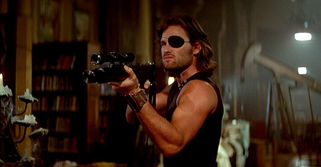 Escape From New York/Бягство от Ню Йорк
Помните ли го Кърт Ръсел? Последните години се позагуби, но през 80-те и началото на 90-те той е една от най-горещите екшън звезди на Холивуд. Кариерата му започва далеч преди това, още като тийнейджър, но истинският му пробив идва с нискобюджетния футуристичен “Бягство от Ню Йорк”. Той става толкова успешен, че много хора и до днес свързват превръзката за очи със Снейк Плискин, а не с еднооките пирати.
Историята е класически постакалиптичен разказ за тогавашното бъдеще през 1997 г, когато остров Манхатън е превърнат в гигантски затвор за най-ужасните престъпници. Американският президент е похитен, а единственият човек, който може да го освободи е Снейк Плискин.